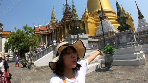 Asian vlogger woman is shooting her own video while traveling in Phra Kaew Temple in Bangkok, Thailand. photo