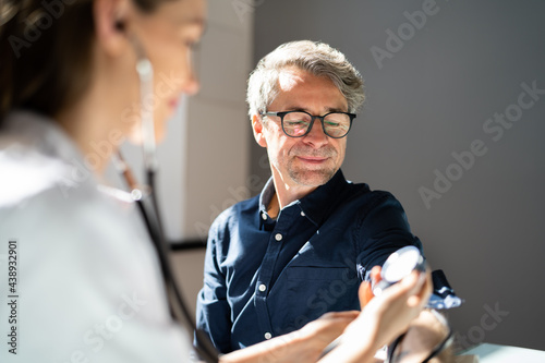 Doctor Measuring Blood Pressure Of Patient photo