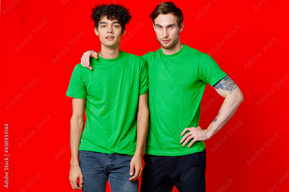two men in green t-shirts are standing side by side communication isolated background two men in green t-shirts are standing side by side communication isolated background
