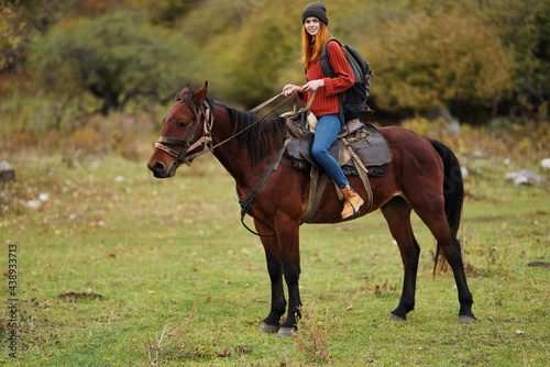woman hiker in the mountains riding a horse travel lifestyle