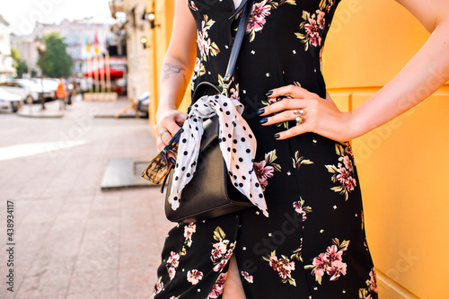 Outdoor fashion portrait of stylish blonde woman wearing sexy vintage midi floral dress