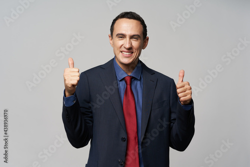 Cheerful business man in a suit gestures with his hands a smile of self-confidence