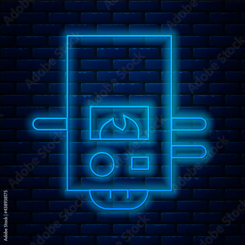 Glowing neon line Gas boiler with a burning fire icon isolated on brick wall background. Vector