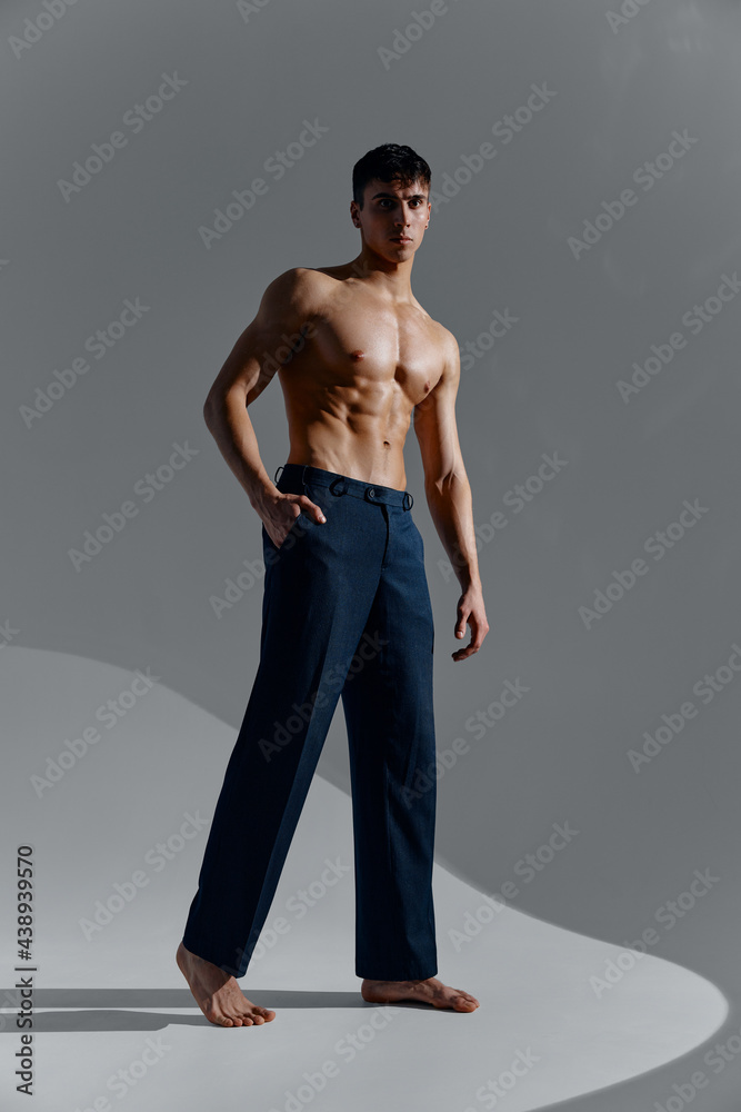 sports guy in jeans and boots on a gray background naked muscles belly torso sports guy in jeans and boots on a gray background naked muscles belly torso