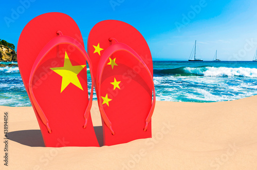 Flip flops with Chinese flag on the beach. China resorts, vacation, tours, travel packages concept. 3D rendering