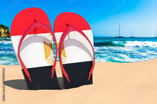 Flip flops with Egyptian flag on the beach. Egypt resorts, vacation, tours, travel packages concept. 3D rendering