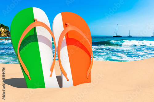 Flip flops with Irish flag on the beach. Ireland resorts, vacation, tours, travel packages concept. 3D rendering