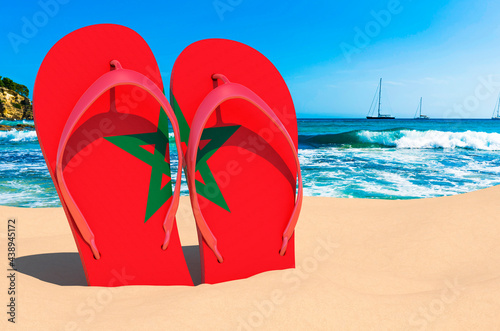 Flip flops with Moroccan flag on the beach. Morocco resorts, vacation, tours, travel packages concept. 3D rendering