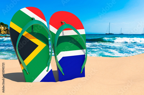 Flip flops with South African flag on the beach. South Africa resorts, vacation, tours, travel packages concept. 3D rendering