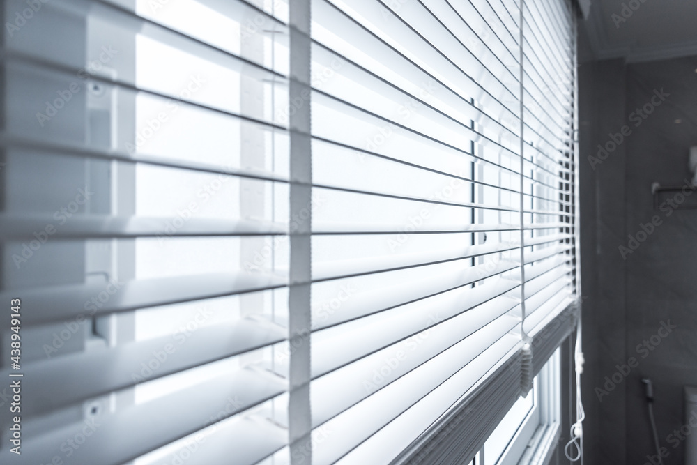 white curtain roll behind a glass window. white curtain roll behind a glass window.