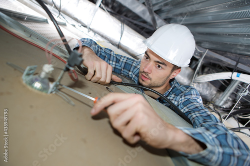 electrician man worker installing ceiling lamp