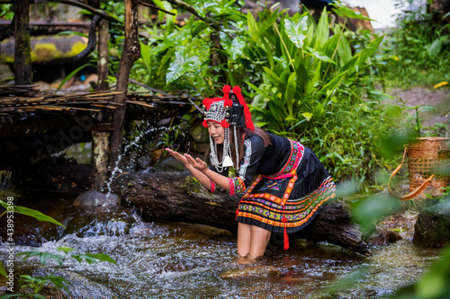 A young hill tribe woman is playing in the water on the waterfall.