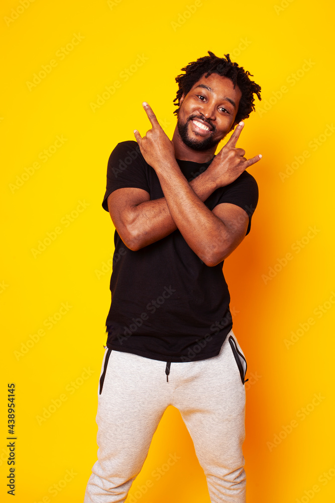 young handsome african american guy student posing cheerful and gesturing on yellow background, lifestyle people concept young handsome african american guy student posing cheerful and gesturing on yellow background, lifestyle people concept