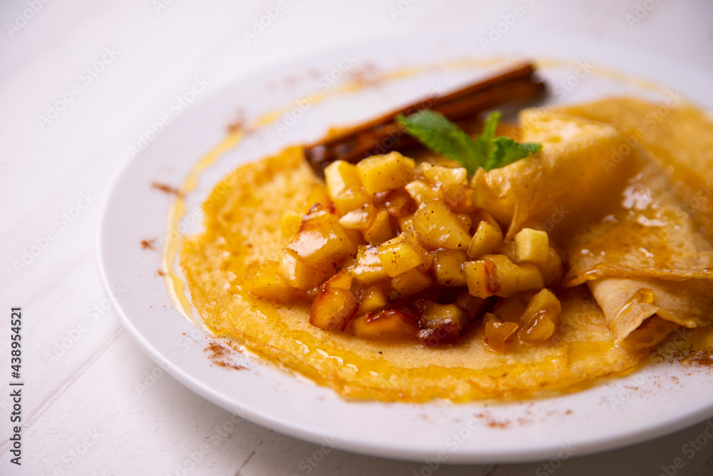 Mini crepes with apple compote and cinnamon. Traditional French recipe.