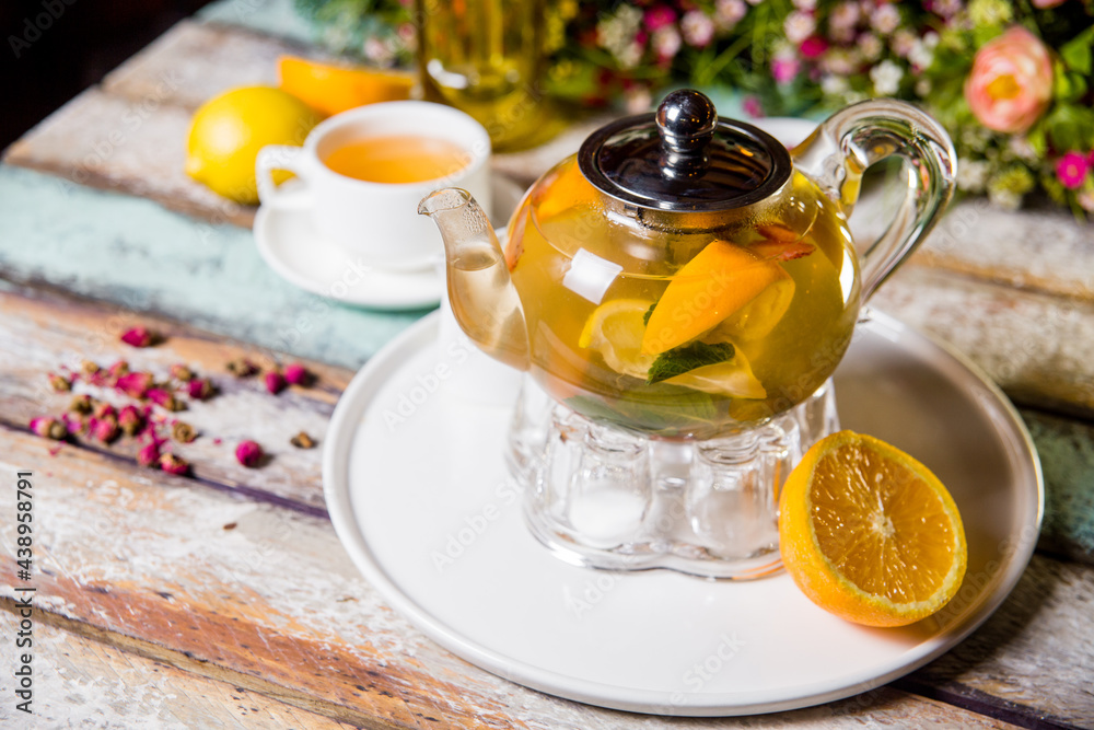 glass kettle of green tea with lemon and mint on a wooden background glass kettle of green tea with lemon and mint on a wooden background