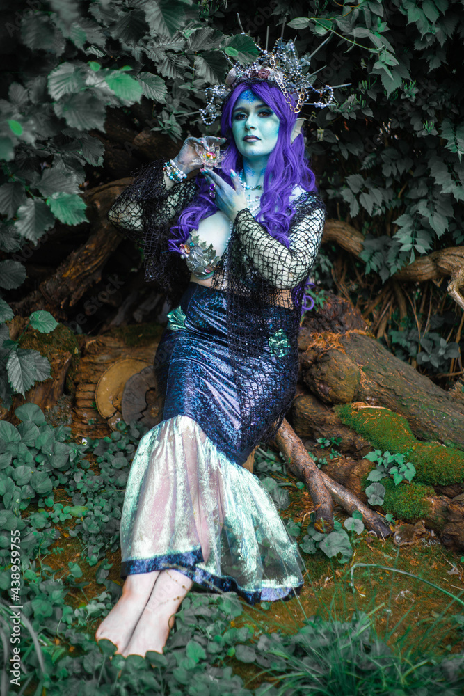 Obraz premium fabulous dark mermaid with blue skin in the forest close up