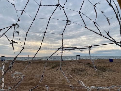 old torn soccer net on a deserted beach