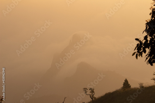 View of rangaswamy peek in kodanadu in the early morning. clouds passing or touching top of the peek or mountain in kodanadu