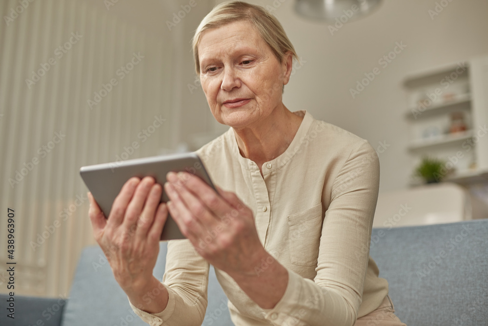 Senior woman using digital tablet at home. The use of technology by the elderly. Senior woman using digital tablet at home. The use of technology by the elderly.