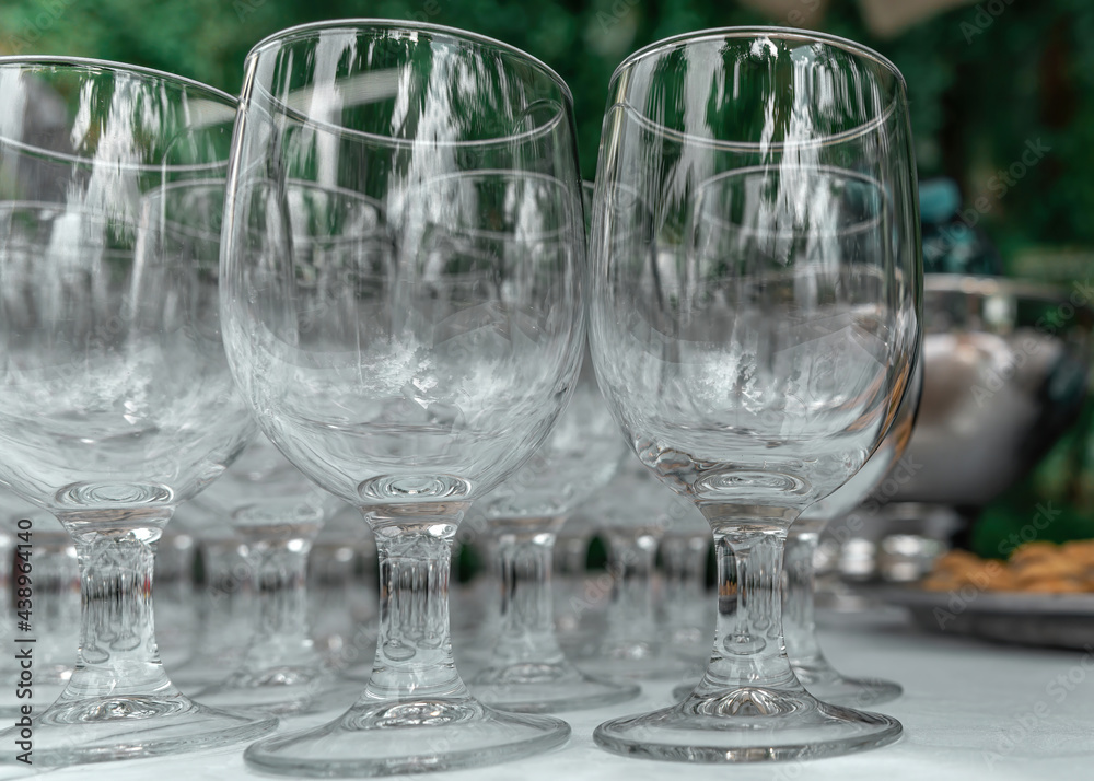 Empty glass transparent wine glasses on a table on a blurry background. Wine glasses in row. Selective focus, close up Empty glass transparent wine glasses on a table on a blurry background. Wine glasses in row. Selective focus, close up