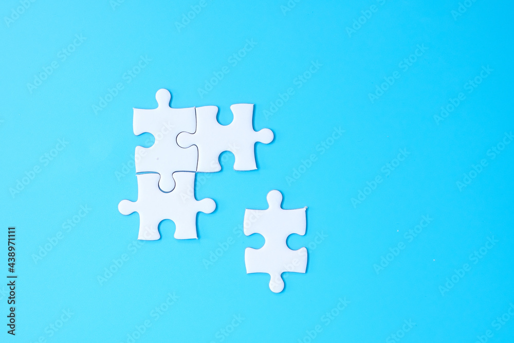 Group of white puzzle jigsaw pieces on blue background. Concept of solutions, mission, success, goals, cooperation, partnership, strategy and puzzle day Group of white puzzle jigsaw pieces on blue background. Concept of solutions, mission, success, goals, cooperation, partnership, strategy and puzzle day