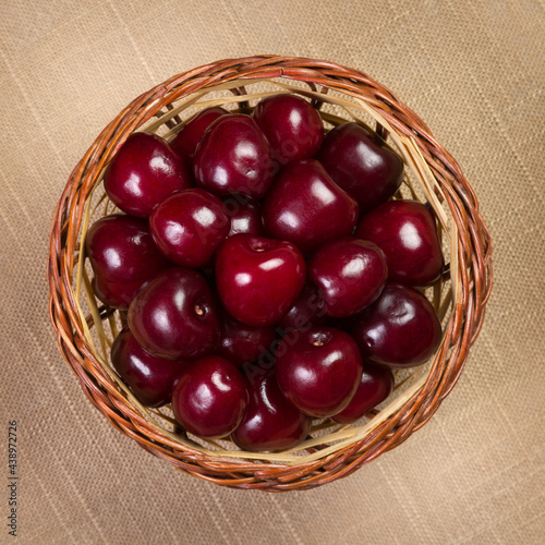 Cherry in a wicker basket on linen