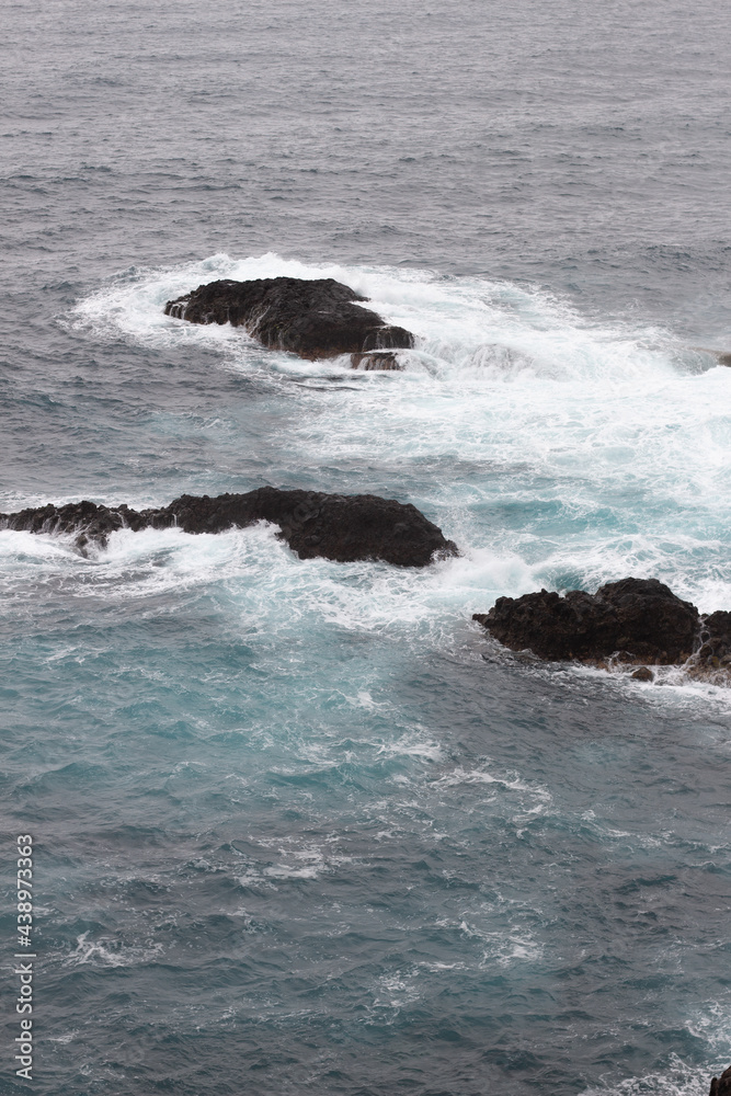 mar con rocas dentro del mar color azul, olas