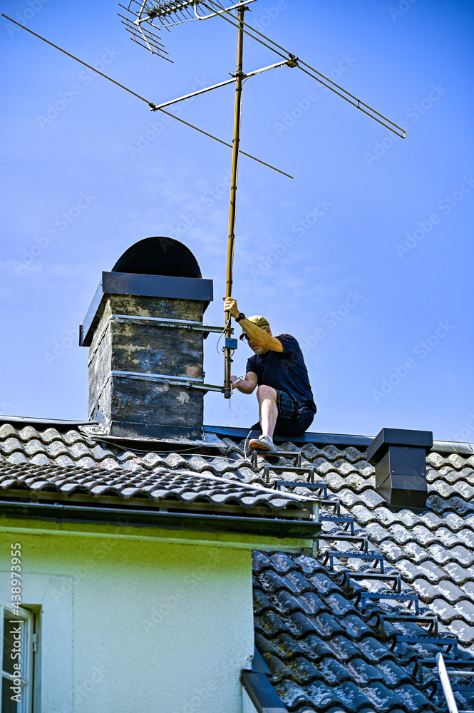 a man taking down an old tv-antenna a man taking down an old tv-antenna