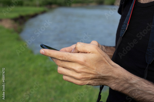 phone in man hand close up nature background