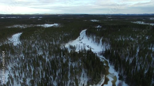 Flight over small frozen stream Petikan in Swedish Lapland