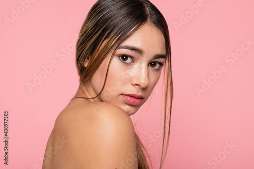 Beauty face. Happy young woman getting ready for romantic valentines day date, applying makeup and smiling. Pretty girl standing naked, nourish and hydrate skin on pink background.