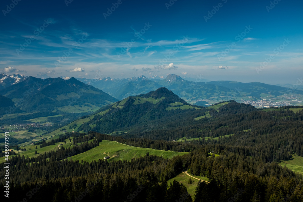 Fototapeta premium Panoramic landscape view of the Swiss Alpes,with blue sky in the background, shot in La Berra, Gruyère, Switzerland