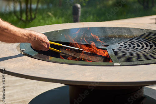 Kettle Grill Pit with Cast Iron Grid with flames . Round table-cooking surface. Hot BBQ on Backyard