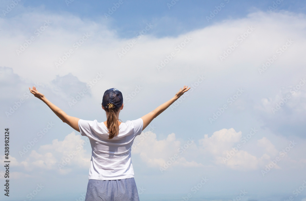 Woman with arms raised up to blue sky, celebrating freedom. Woman with arms raised up to blue sky, celebrating freedom.