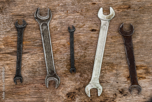 A lot of old wrenches. The working set of wrenches on cracked plywood background.