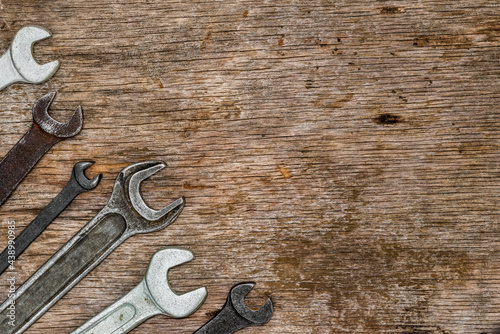 A lot of old wrenches. The working set of wrenches on cracked plywood background.