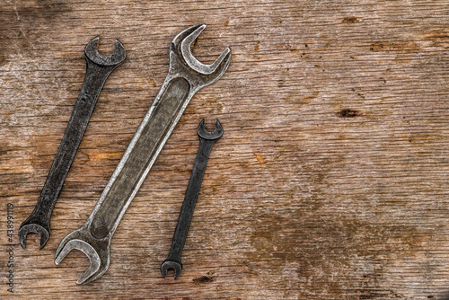 A lot of old wrenches. The working set of wrenches on cracked plywood background.