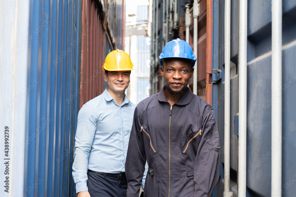 Selective focus at African black worker while talk and having discussion with supervisor and inspect the condition of all containers shipment, People and worker in freight deliver, import and export. Selective focus at African black worker while talk and having discussion with supervisor and inspect the condition of all containers shipment, People and worker in freight deliver, import and export.