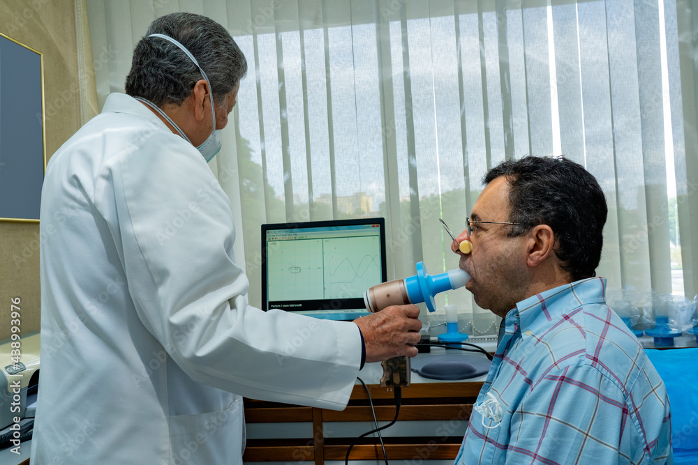 Foto de Mature man performing pulmonary function test and spirometry in ...