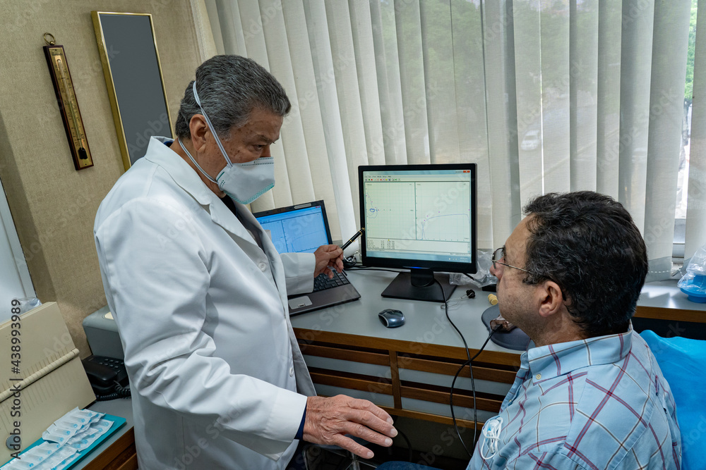 Mature man performing pulmonary function test and spirometry in doctor ...