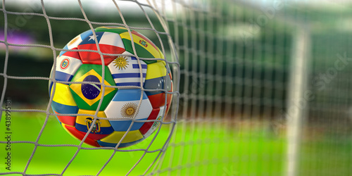 Soccer Football ball with flags of south america countries in net on football stadium. America championship 2021. photo