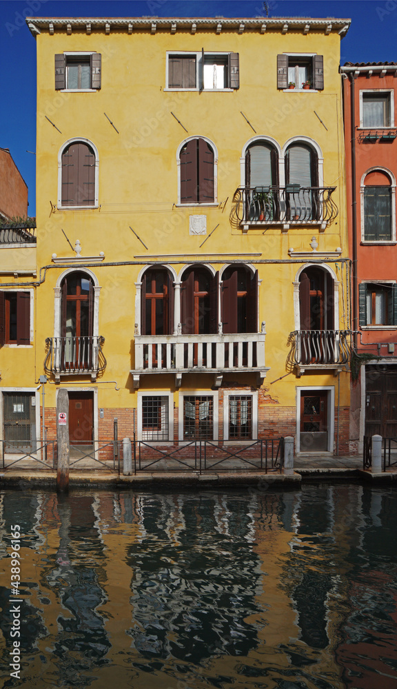 Traditional colorful canal building in Venice, with ornate balconies and beautiful water reflections, Venice, Italy