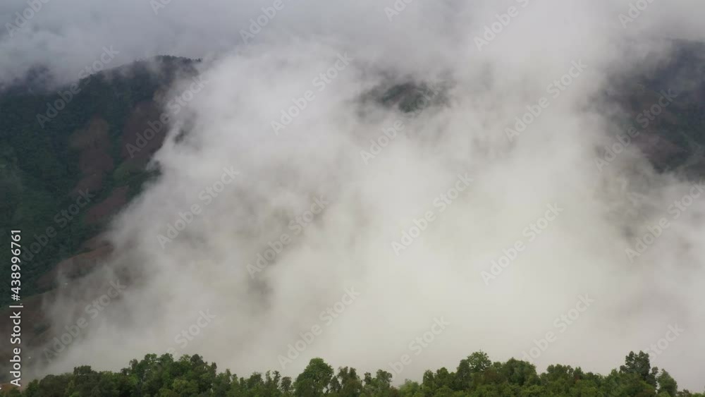 Aerial view flying above lush green tropical rain forest mountain with rain cloud cover during the rainy season on the Doi Phuka Mountain reserve national park. In, the northern Thailand Aerial view flying above lush green tropical rain forest mountain with rain cloud cover during the rainy season on the Doi Phuka Mountain reserve national park. In, the northern Thailand