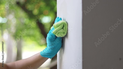 Cleaning staff wipes the walls, use a towel moistened with cleaning solution to rub the wall, Text fill area, White background, Eliminate germs during the virus outbreak.