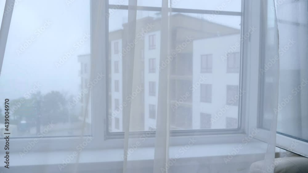 Moving transparent curtains on the window on a rainy day Moving transparent curtains on the window on a rainy day