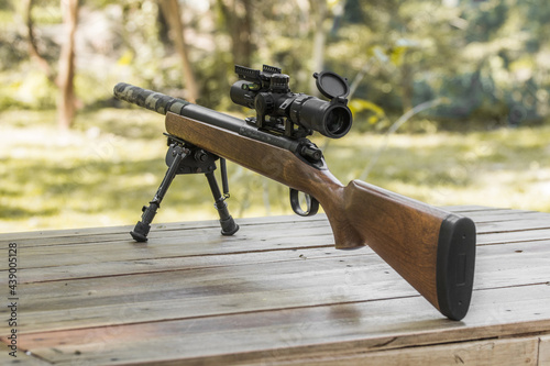 Wooden sniper rifle with scope and bipod photo