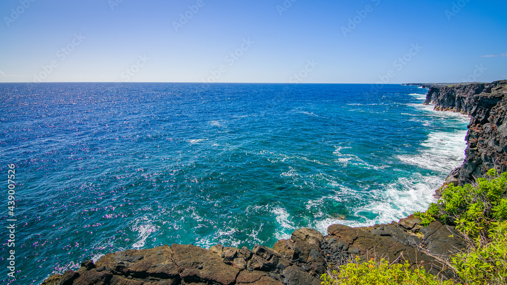 Cliffs on the seashore. Large boulder among the waves in the sea. Hōlei Sea Arch, Big island. Hawaii
