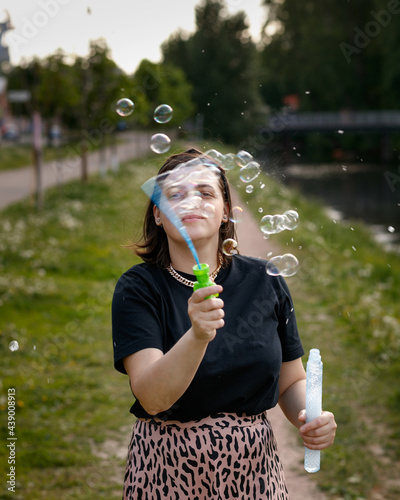 A woman plays with soap bubbles. portrait of a girl in the city