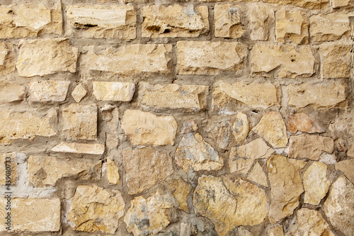 Close-up of a fragment of an old natural white limestone wall.