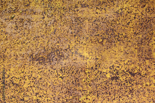 Yellow peeling paint on a rusty metal abstract wall. Old rusty background